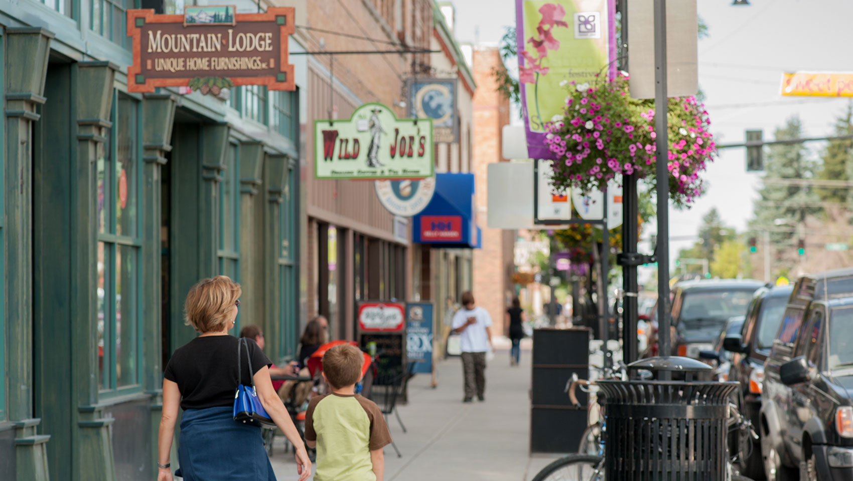 mother and son walking on sidewalk of downtown bozeman