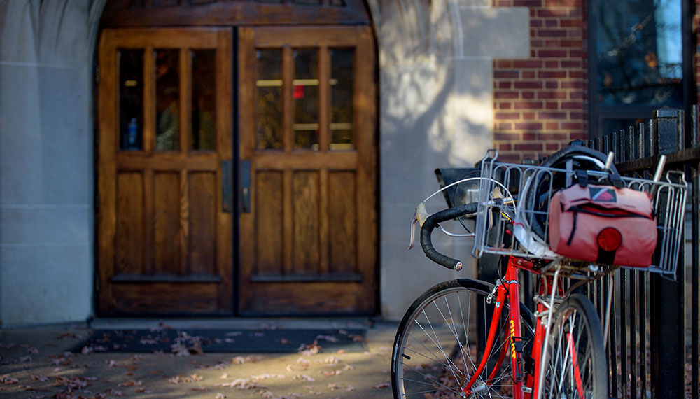 wooden door with bicycle parked in front on university campus