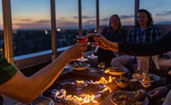 Group cheersing drinks at Sky Shed at sunset