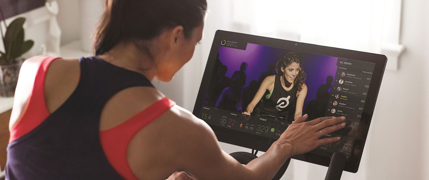 woman using the screen on a Peloton bike